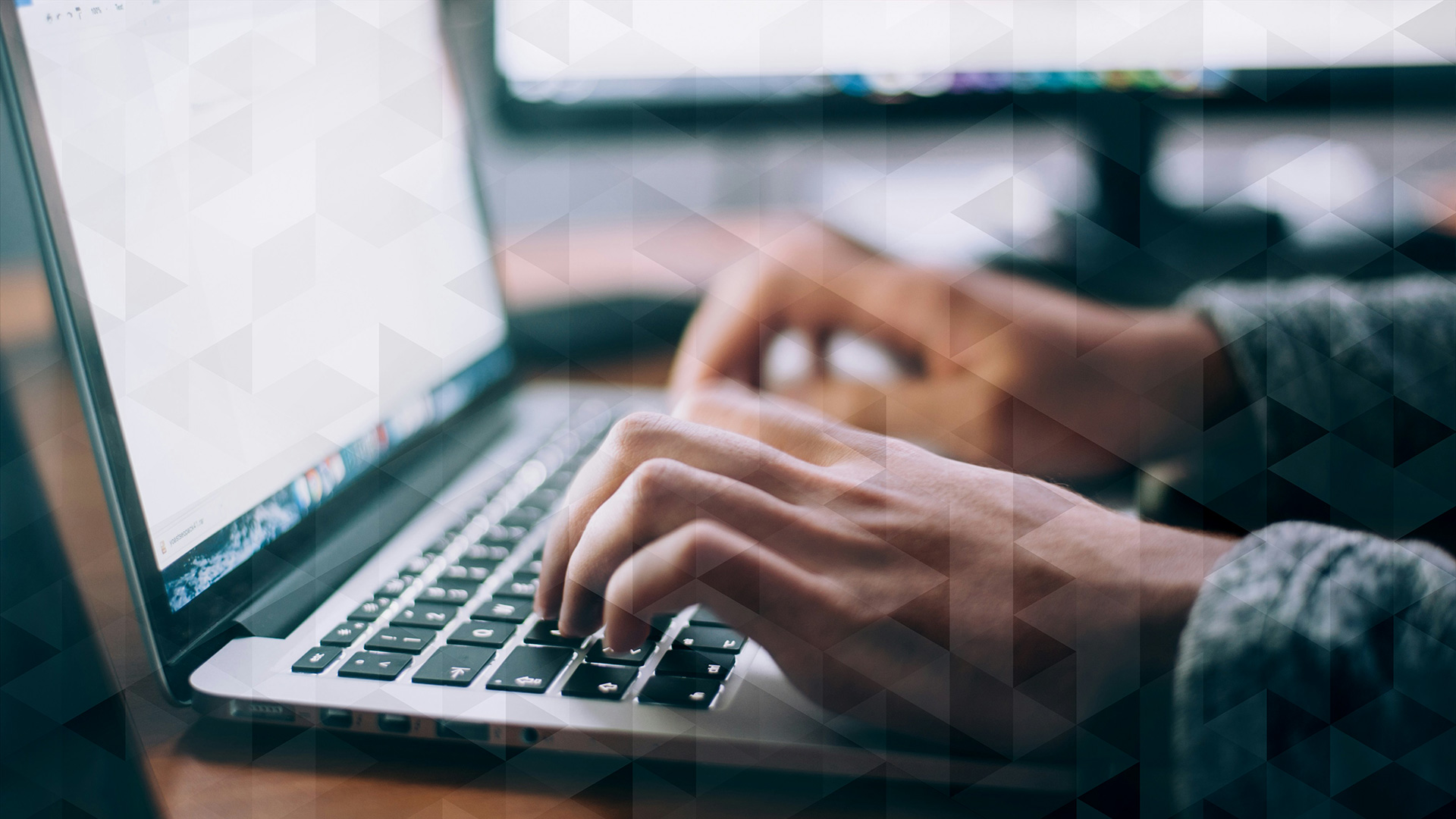 Hands typing on a laptop keyboard