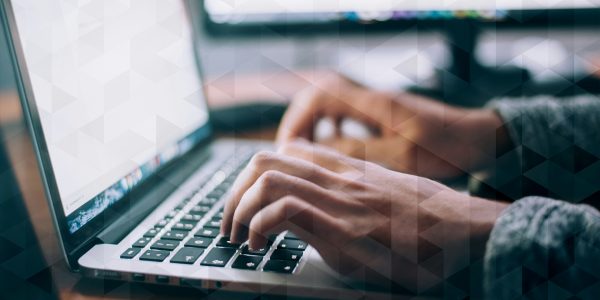 Hands typing on a laptop keyboard