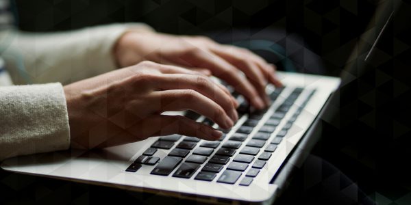 Hands typing on a laptop keyboard